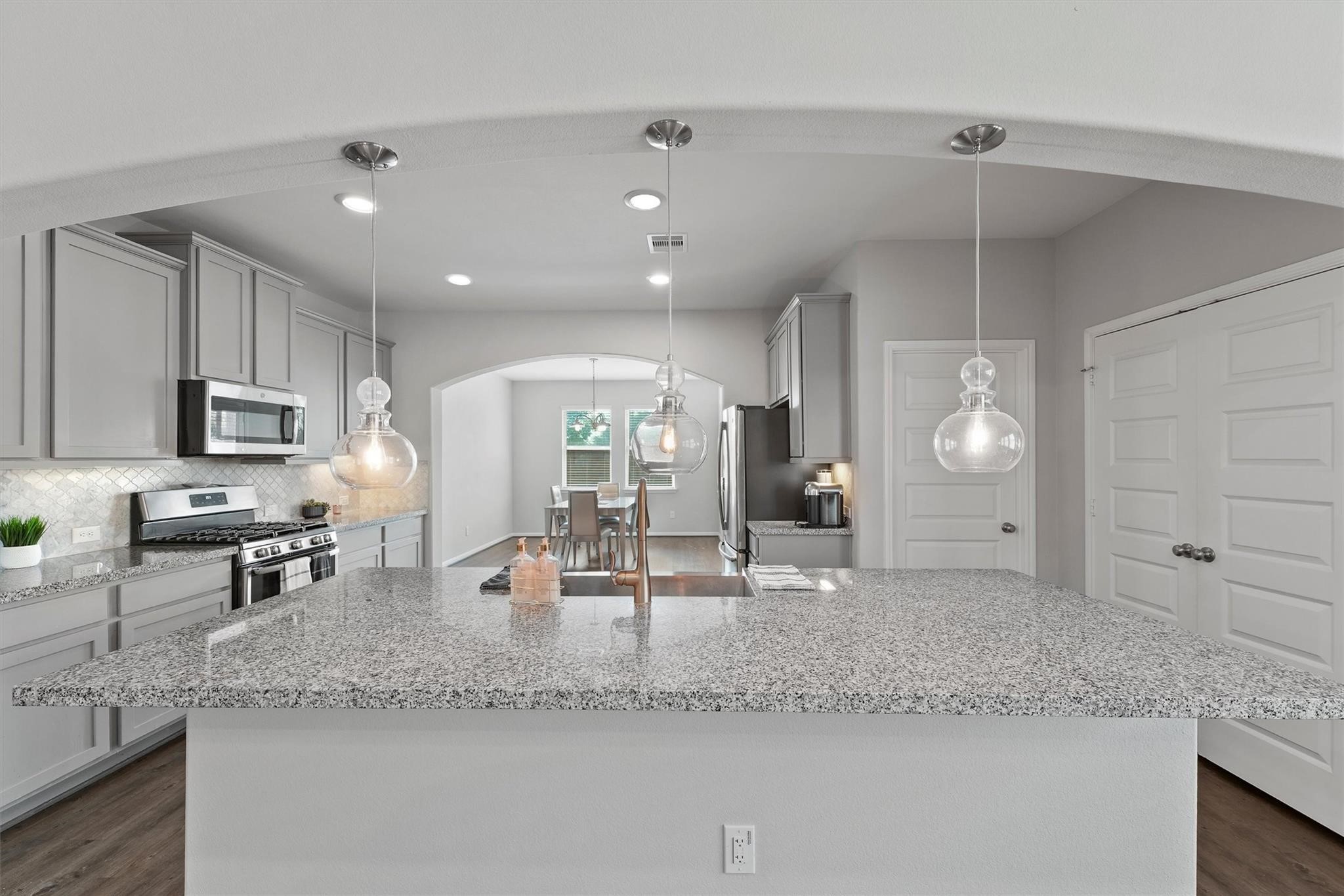 15103 Dry Ridge Court Humble, TX 77346 - Photo 9 of 28 a large kitchen with granite countertop a sink a counter top space and cabinets