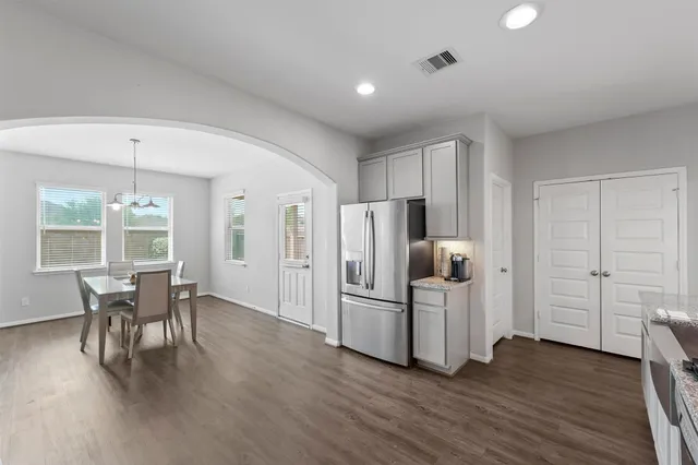 a kitchen with stainless steel appliances a refrigerator and wooden floor