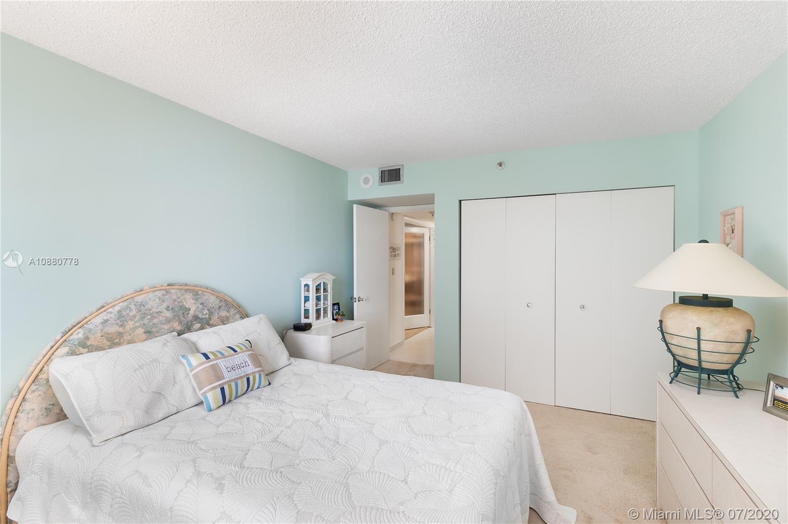 8777 Collins Avenue, Unit 611 Surfside, FL 33154 - Photo 14 of 22 a bedroom with a bed and a chandelier