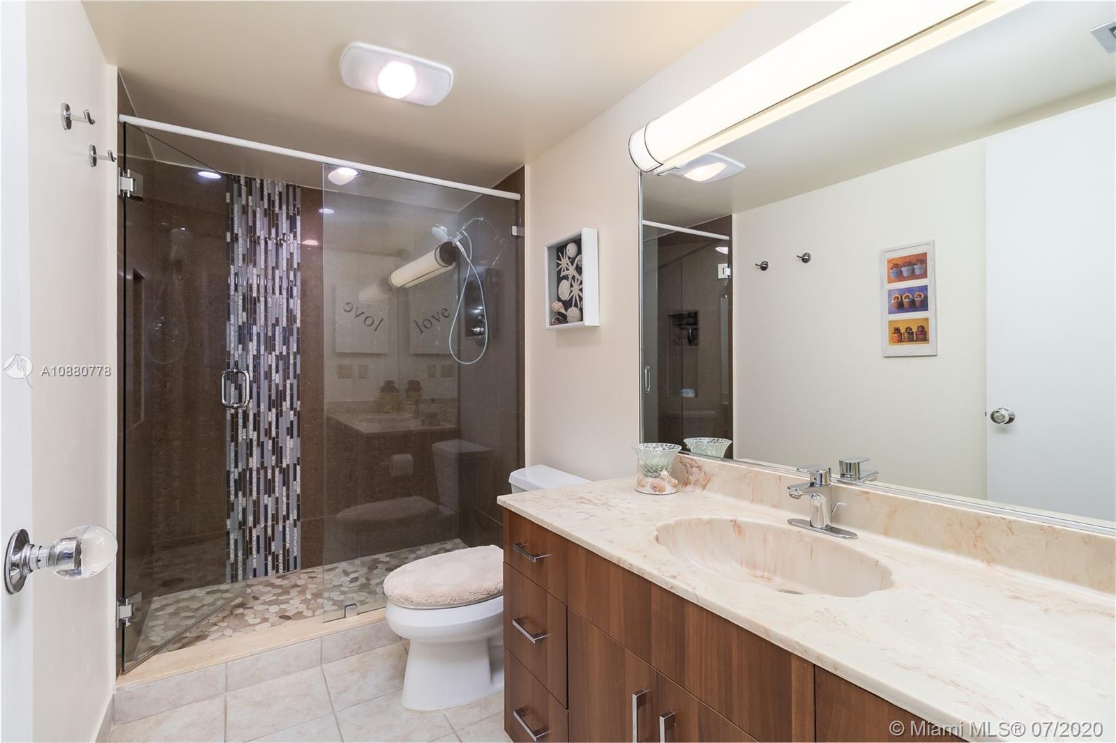 8777 Collins Avenue, Unit 611 Surfside, FL 33154 - Photo 16 of 22 a bathroom with a granite countertop sink toilet and shower