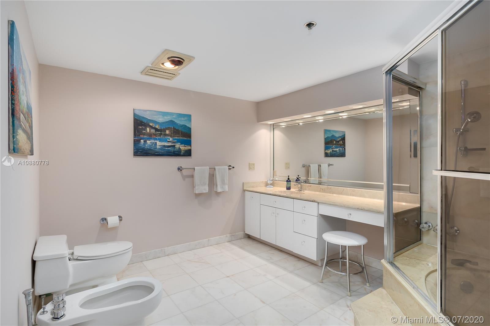 8777 Collins Avenue, Unit 611 Surfside, FL 33154 - Photo 18 of 22 a bathroom with a sink mirror and toilet