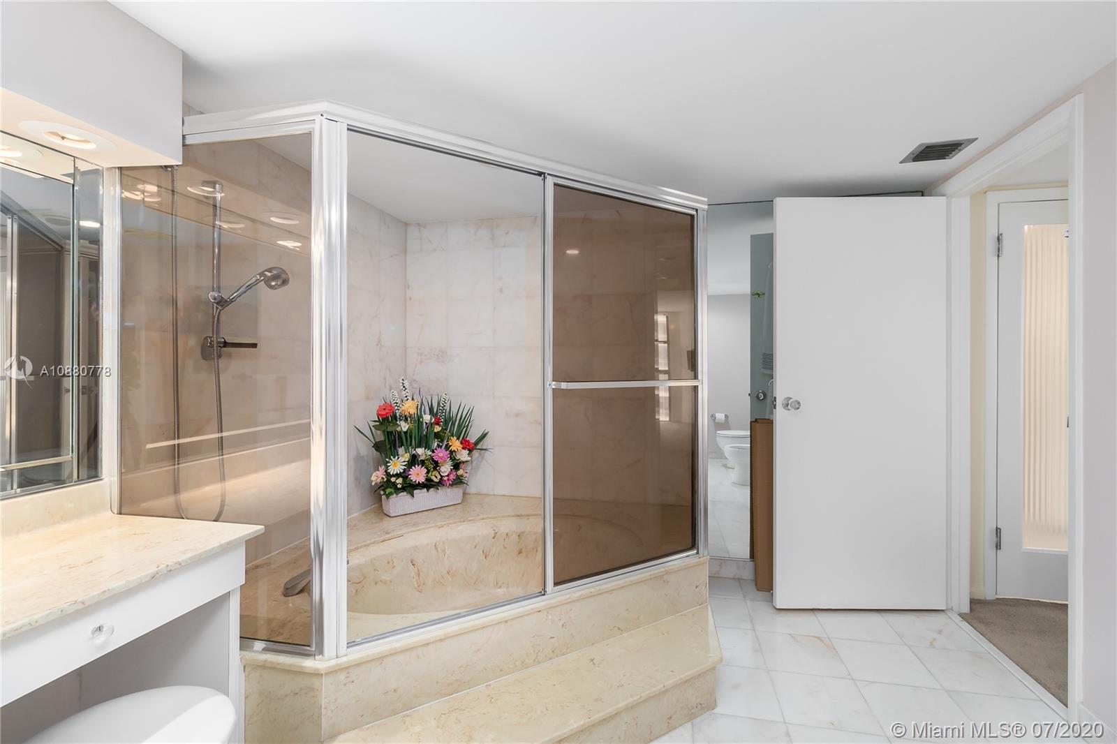 8777 Collins Avenue, Unit 611 Surfside, FL 33154 - Photo 19 of 22 a bathroom with a shower and a sink