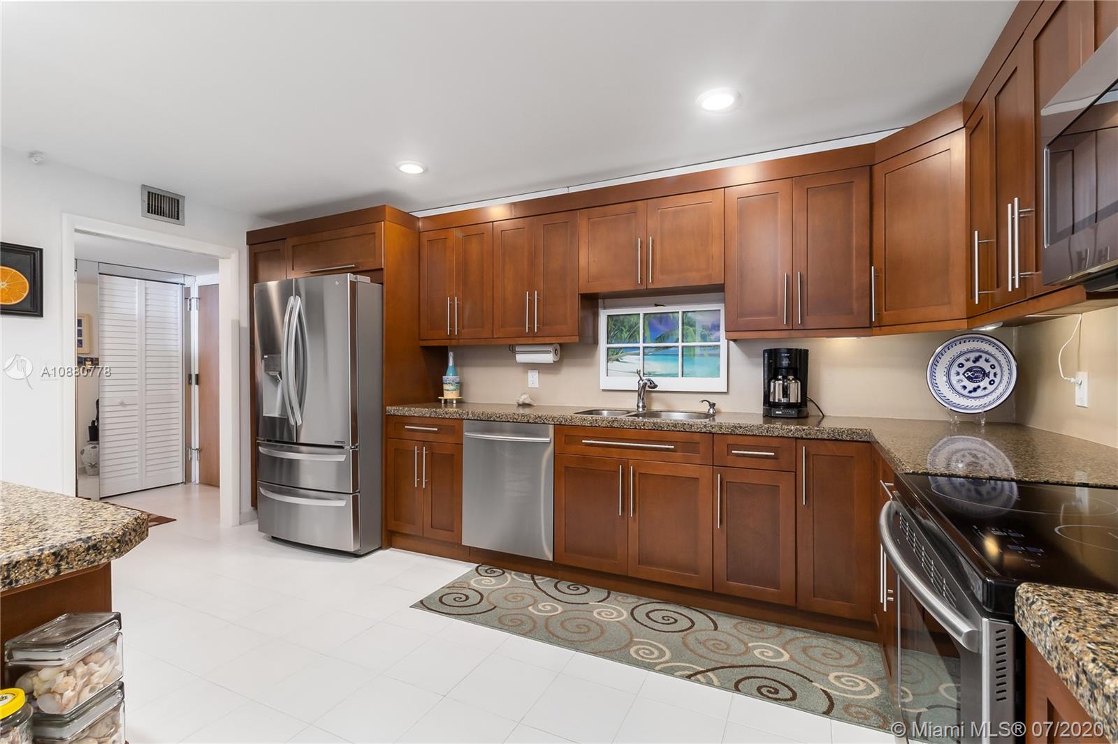 8777 Collins Avenue, Unit 611 Surfside, FL 33154 - Photo 8 of 22 a kitchen with stainless steel appliances granite countertop a refrigerator stove and sink