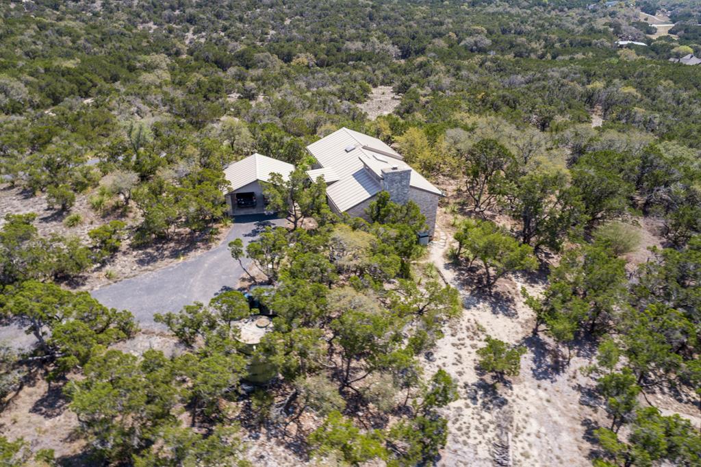 an aerial view of a house with a yard and large tree