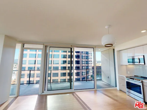 a view of an empty room with a fireplace and windows