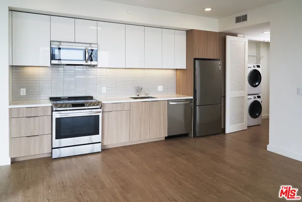 a kitchen with cabinets and stainless steel appliances