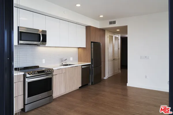 a kitchen with stainless steel appliances a stove a microwave and a refrigerator