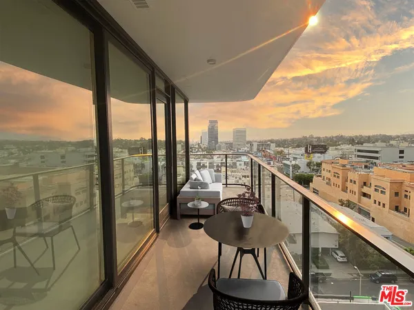a view of a balcony with furniture and city view