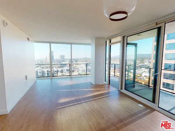 a view of a room with wooden floor and window