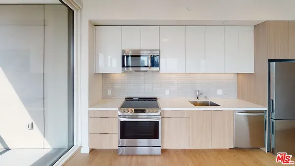 a kitchen with stainless steel appliances a refrigerator sink and white cabinets