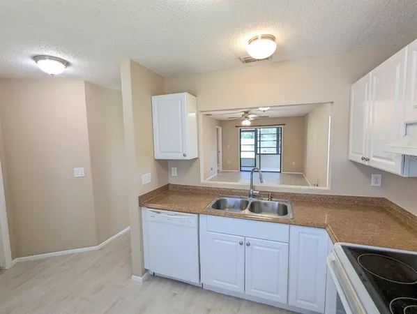 a kitchen with granite countertop white cabinets and sink