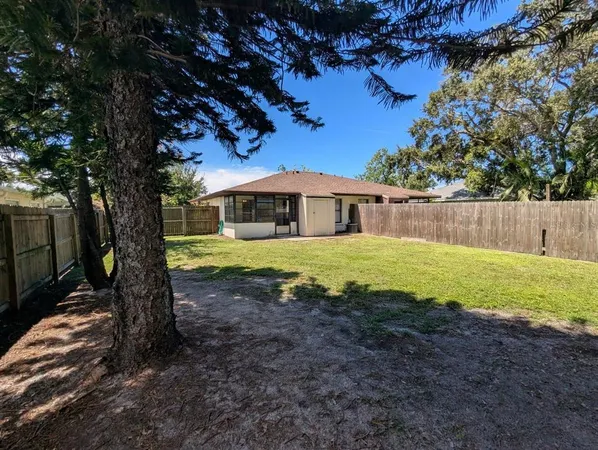 a view of a house with backyard and a tree