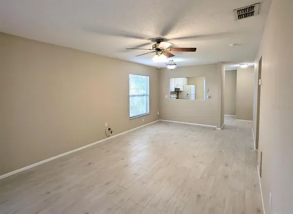 an empty room with windows and fan