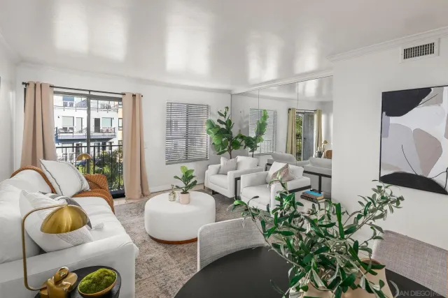 a living room with furniture and floor to ceiling windows