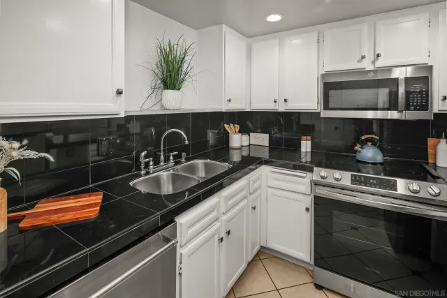 a kitchen with sink a microwave and cabinets