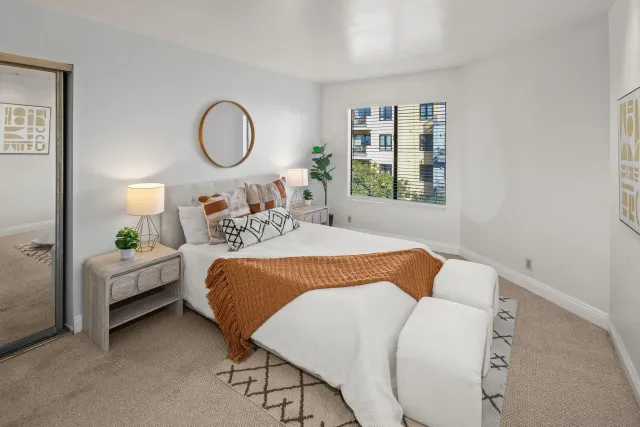 a bed room with a bed mirror and a window