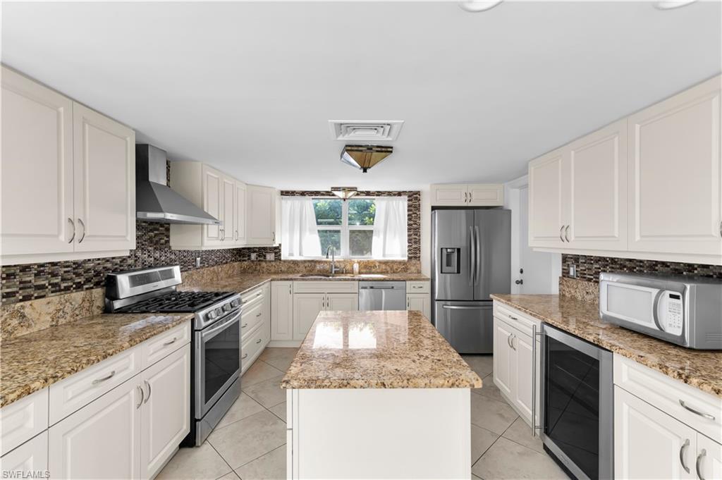 875 Robin Court Marco Island, FL 34145 - Photo 16 of 30 a large kitchen with granite countertop a stove sink and refrigerator