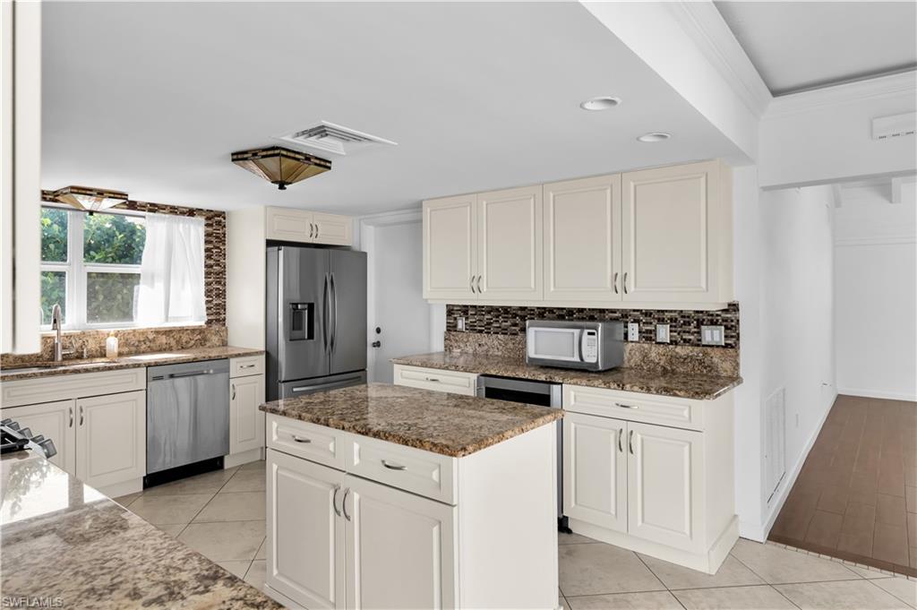875 Robin Court Marco Island, FL 34145 - Photo 17 of 30 a kitchen with granite countertop a sink and white cabinets