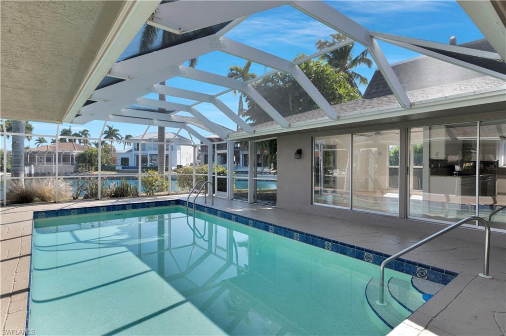 875 Robin Court Marco Island, FL 34145 - Photo 4 of 30 a swimming pool with outdoor seating