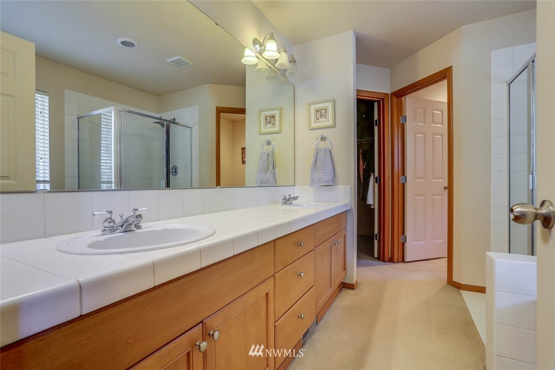 363 Pasco Drive Northeast Renton, WA 98059 - Photo 16 of 26 a spacious bathroom with a double vanity sink a mirror and a shower