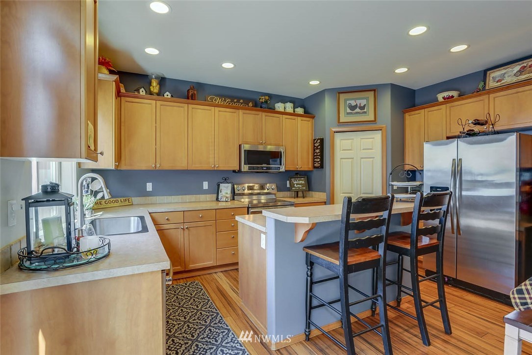 363 Pasco Drive Northeast Renton, WA 98059 - Photo 8 of 26 a kitchen with stainless steel appliances granite countertop a sink a stove a refrigerator cabinets and chairs