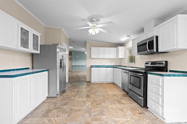 a kitchen with granite countertop a stove a sink and a refrigerator