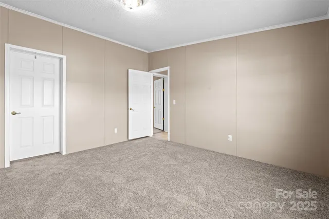 an empty room with closet and a ceiling fan