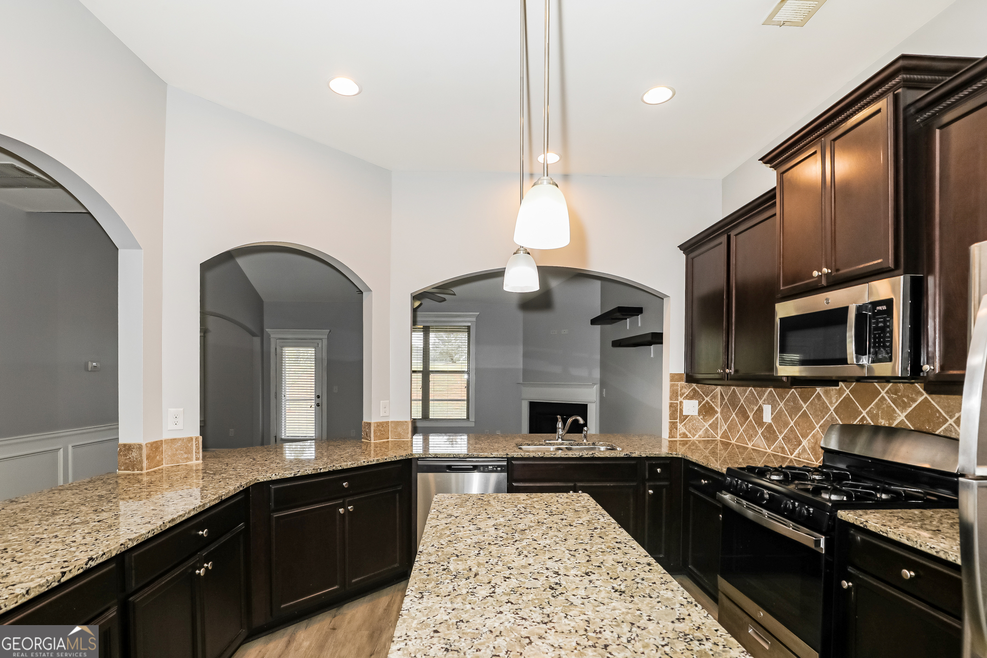 3216 Alhambra Circle Hampton, GA 30228 - Photo 7 of 21 a large kitchen with stainless steel appliances granite countertop a stove a sink and a microwave