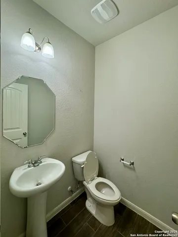 a bathroom with a toilet sink and mirror