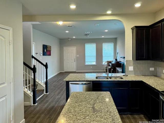a kitchen with kitchen island stainless steel appliances a sink stove and cabinets