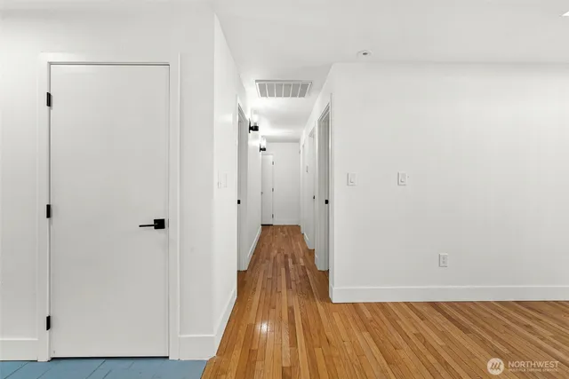 a view of a room with wooden floor and a hallway