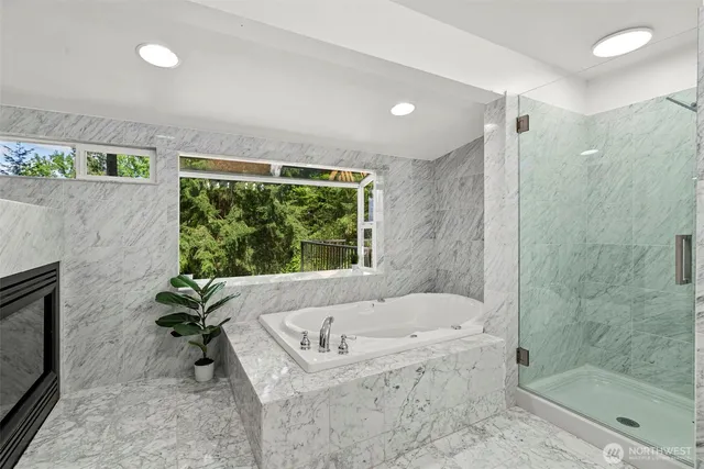 a white bath tub sitting in a bathroom next to a window