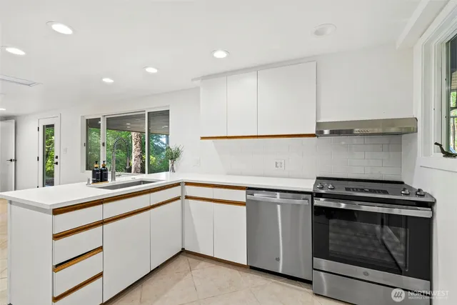 a kitchen with a stove and white cabinets