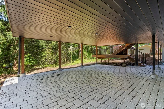 a view of a patio with a table and chairs next to a yard