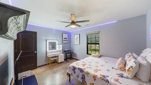 a bedroom with a bed flat screen tv and a large window