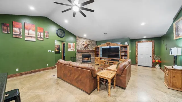 a living room with furniture a flat screen tv and a fireplace