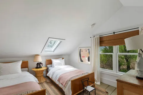 a bedroom with two beds and a large window