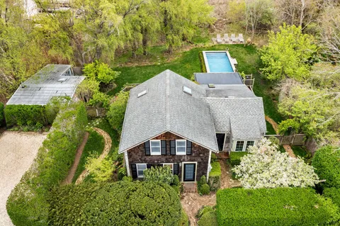 an aerial view of a house with a yard and trees