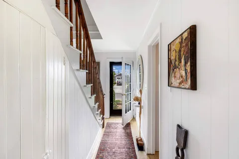 a view of staircase with lots of frames on wall and a window