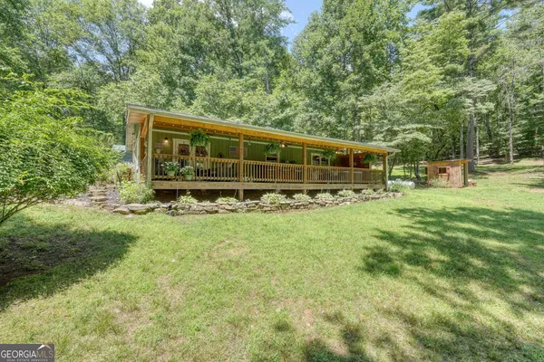 a view of a house with backyard and sitting area
