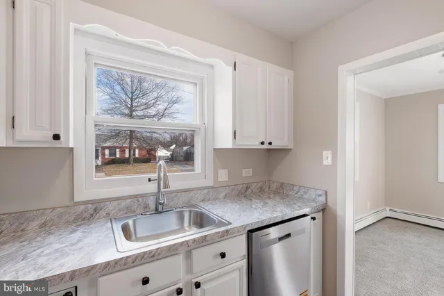 a kitchen with a sink cabinets and a window