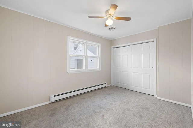 an empty room with windows and ceiling fan