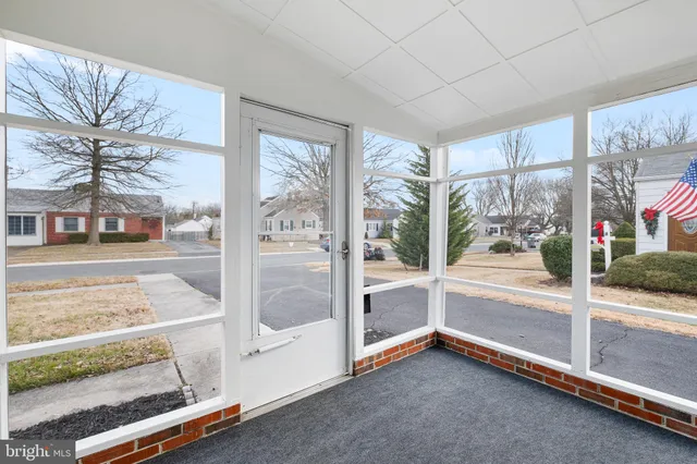 a view of an empty room with a floor to ceiling window and a flat screen tv