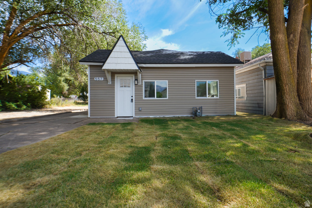 557 Cook Street Ogden, UT 84404 - Photo 1 of 17 Single-story residence featuring siding exterior, a prominent front entry with a decorative gable and shingle siding detail, and a dark shingle roof