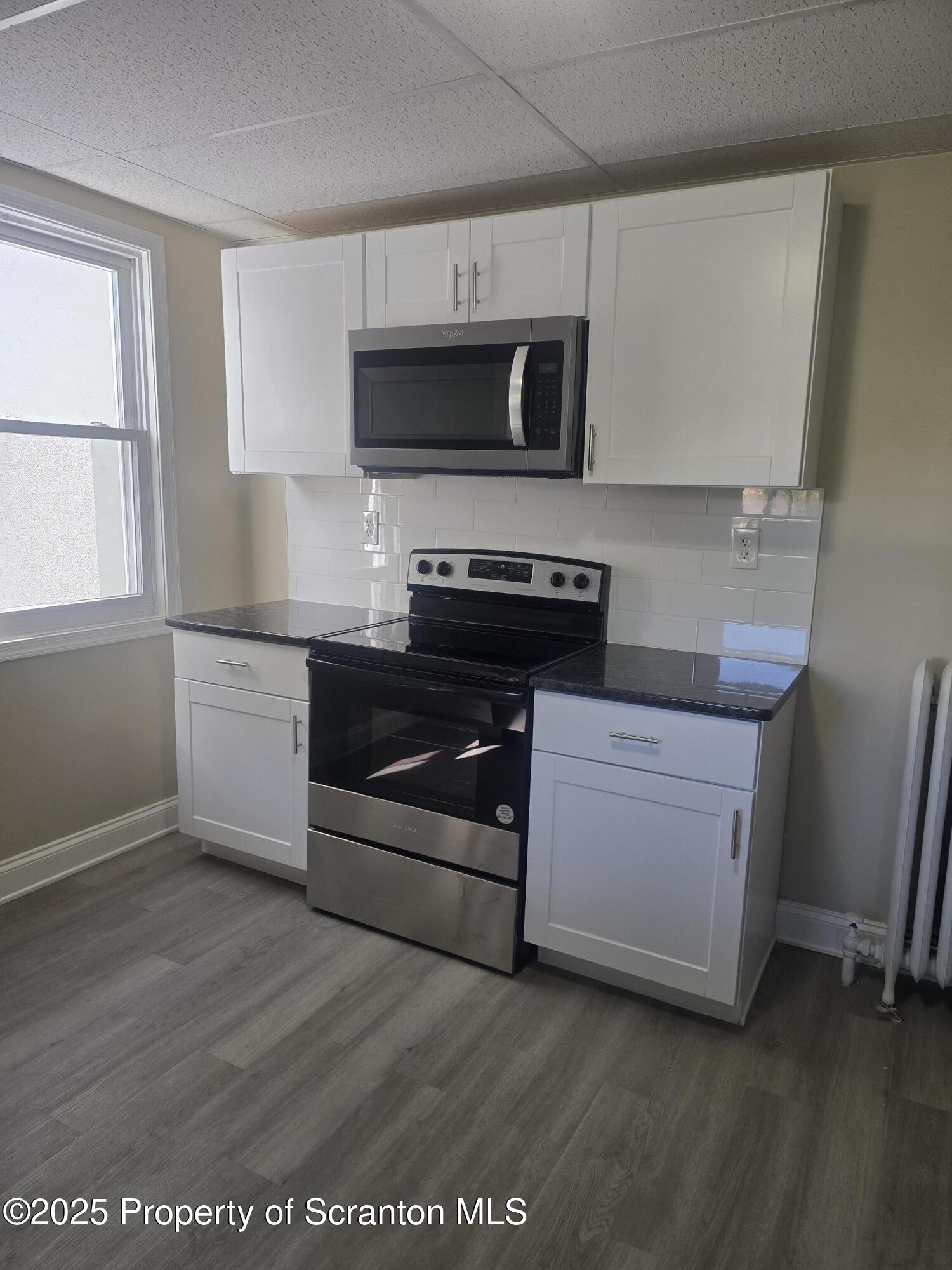 323 Larch Street Scranton, PA 18509 - Photo 3 of 18 a kitchen with stainless steel appliances a stove microwave and sink