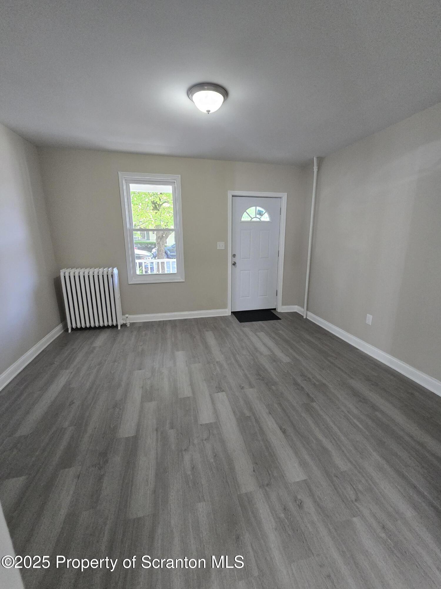 323 Larch Street Scranton, PA 18509 - Photo 10 of 18 an empty room with wooden floor and windows