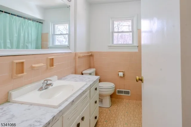 a bathroom with a sink toilet and window