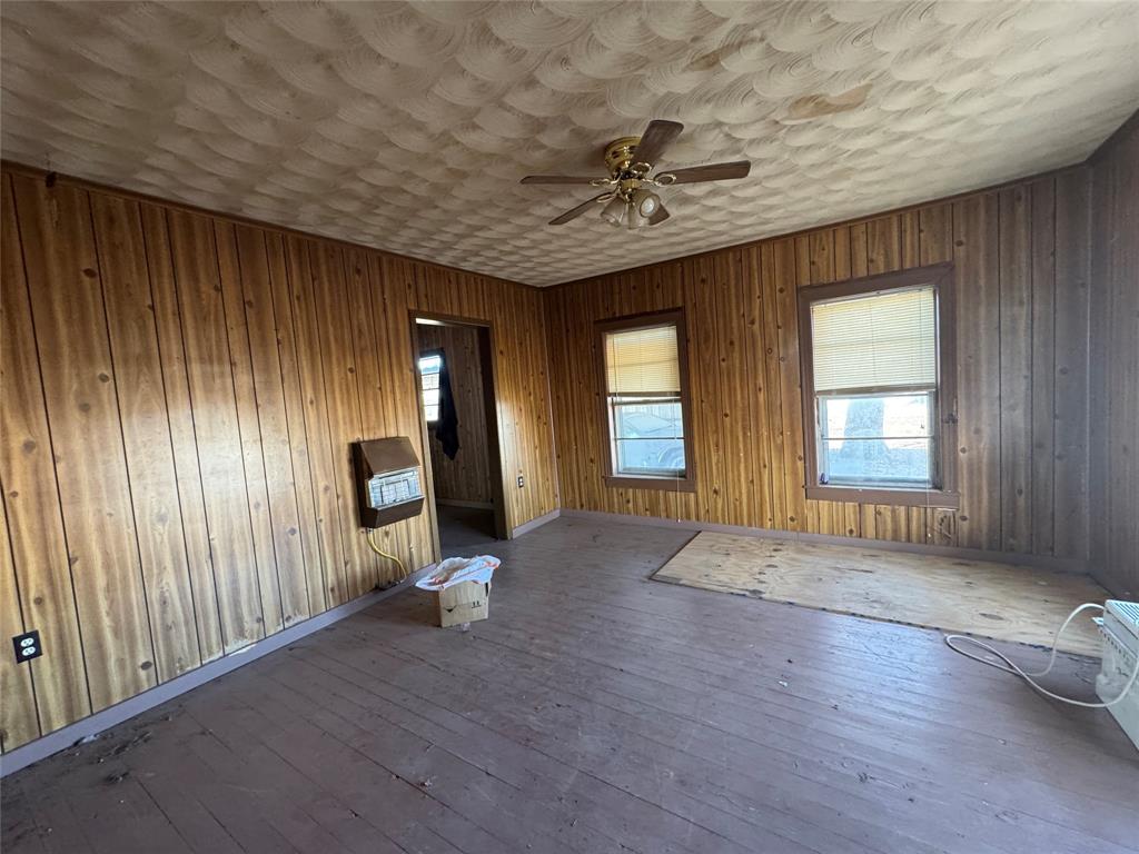 610 5th Street Hawley, TX 79525 - Photo 4 of 19 an empty room with wooden floor fan and windows