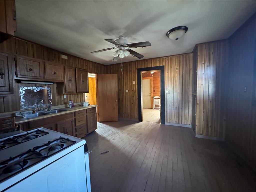 610 5th Street Hawley, TX 79525 - Photo 8 of 19 a kitchen with granite countertop wooden cabinets and a stove top oven
