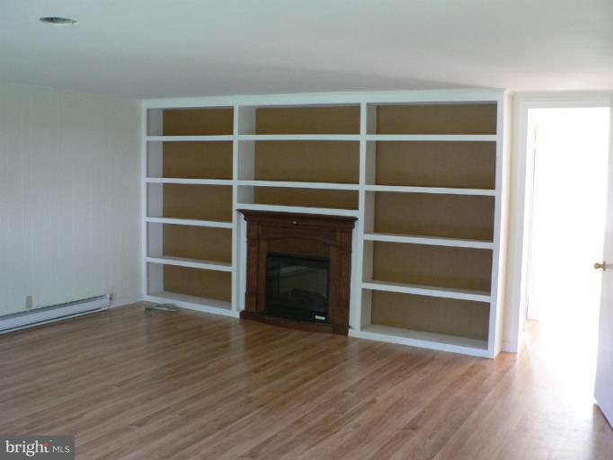 7423 Station Road Newcomb, MD 21653 - Photo 13 of 17 a view of an empty room with a window and wooden floor